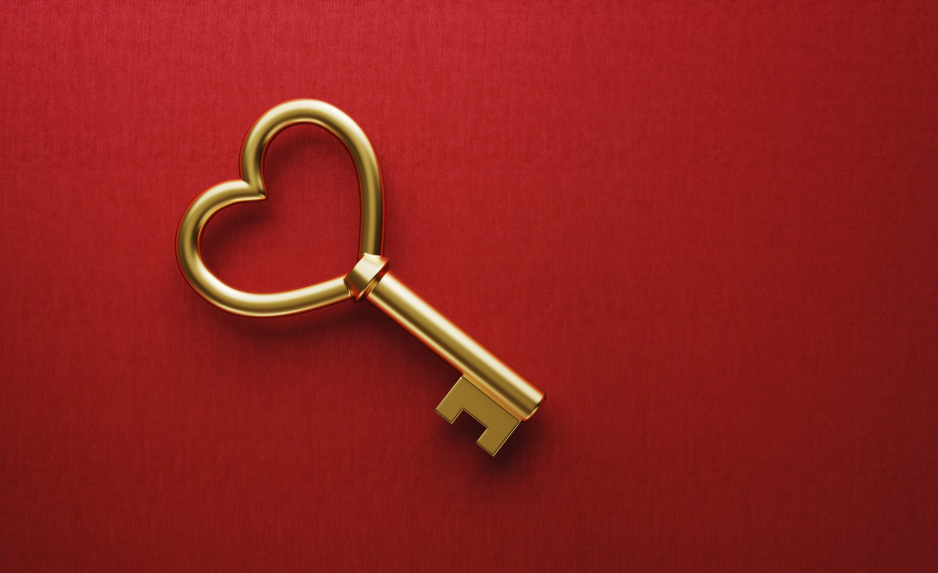 Gold Heart Shaped Key on Red Background Gold Heart Shaped Key on Red Background